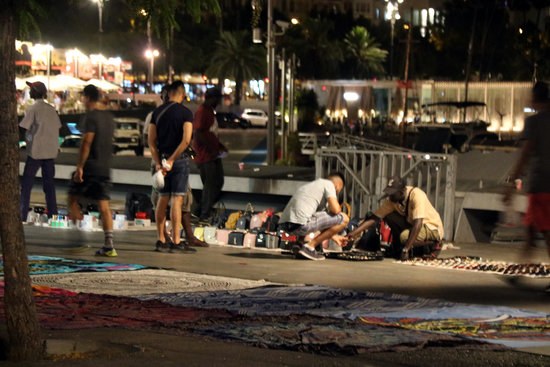 Some street sellers setting up their shops after police patrol ends at 10pm on July 29, 2019 (by Miquel Codolar)